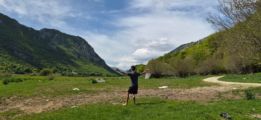 Pratiquant les bras ouverts face à une vallée verdoyante